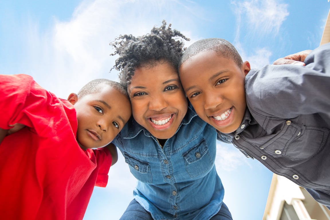 Black mother and children looking down at camera